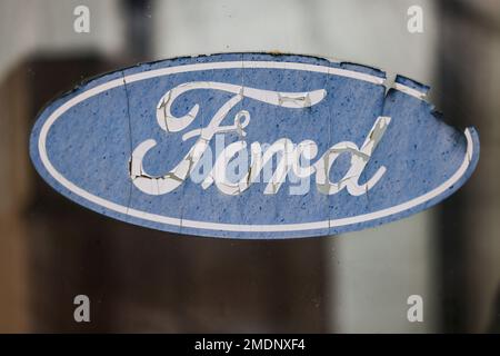 Köln, Deutschland. 23. Januar 2023. Ein abgelöstes Ford Logo hängt an einem Fenster vor dem Werksgelände. Nach Angaben des betriebsrats möchte der Automobilhersteller Ford an seinem Standort in Köln in großem Umfang Arbeitsplätze abbauen. Wenn das Management seinen aktuellen Plan durchsetzt, könnten bis zu 3200 Arbeitsplätze eliminiert werden. (Dpa: 'IG Metall: Ford will bis zu 3200 Arbeitsplätze in Köln abbauen') Kredit: Oliver Berg/dpa/Alamy Live News Stockfoto