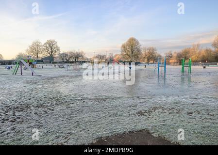 Fordingbridge, Hampshire, England, Vereinigtes Königreich, 23. Januar 2023, Wetter: Während sich der überfließende Fluss Avon zurückzieht, haben mehrere harte Fröste den Spielplatz am Flussufer bedeckt und in dickem Eis geparkt. Kredit: Paul Biggins/Alamy Live News Stockfoto