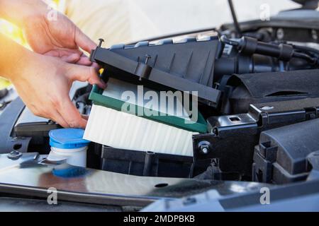 Austausch eines neuen Luftfilters in einem Pkw, Motorraum. Fahrzeugwartung. Der Automechaniker installiert einen neuen Motorluftfilter. Stockfoto