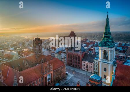 Morgendämmerung über den Dächern der Altstadt von Torun mit Marktplatz, Rathaus, Kirchen und dem Fluss im Hintergrund Stockfoto