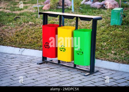 Mehrfarbige Behälter für die getrennte Abfallsammlung bügeln. Abfallrecycling. Stockfoto