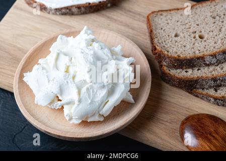 Hausgemachtes Roggenbrot auf einem Holzbrett mit Quark und Ricotta Stockfoto