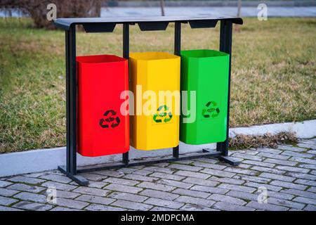 Mehrfarbige Behälter für die getrennte Abfallsammlung bügeln. Abfallrecycling. Stockfoto