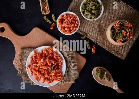 Glutenfreie Fusilli-Pasta aus grüner Erbse und Karotten auf flachem Untergrund. Organische gesunde Lebensmittel für Menschen mit Laktoseintoleranz Stockfoto