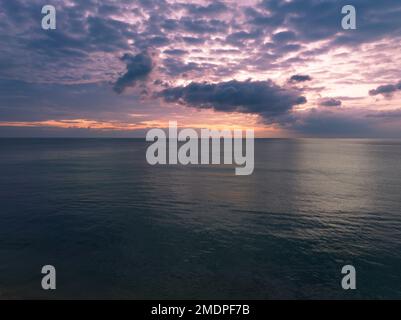 Luftaufnahme Sonnenuntergang Himmel, Natur wunderschönes Licht Sonnenuntergang oder Sonnenaufgang über dunklem Meer, farbenfrohe dramatische majestätische Landschaft Himmel mit unglaublichen Wolken und Wellen i Stockfoto