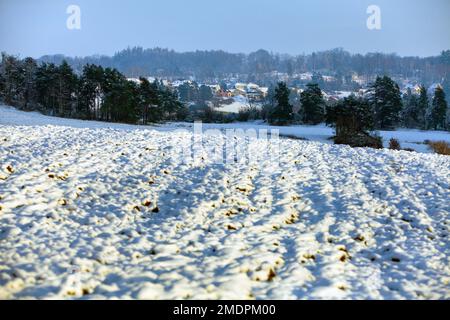 Böhmische und mährische Hochlandschaft, Panoramablick im Winter, schneebewachsenes gepflügtes Feld und Dorf in der Nähe der Stadt Velke Mezirici Stockfoto