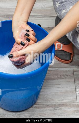 Ein Mann wischte den Boden mit einem Lappen. Nasse Hausreinigung. Ein feuchtes Tuch auswringen Stockfoto