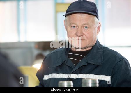 Porträt eines älteren Mannes in Arbeitskleidung. Stockfoto