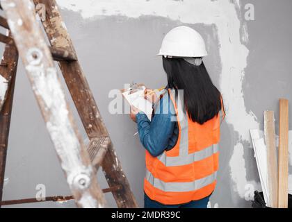 Ein Bauleiter überprüft das Renovierungsprojekt mit einer Checkliste auf der Zwischenablage Stockfoto