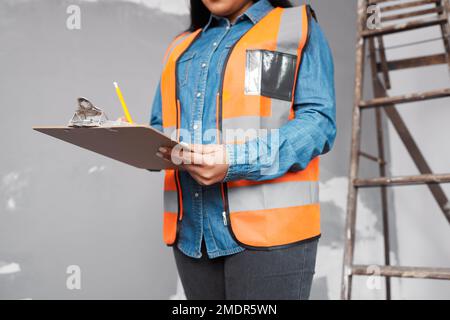 Ein Bauleiter überprüft das Renovierungsprojekt mit einer Checkliste auf der Zwischenablage Stockfoto