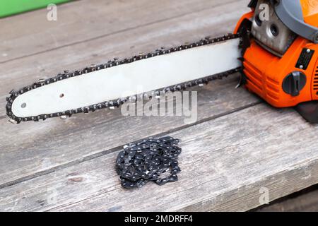 Neue Kette für Motorsäge. Aufbau und Austausch der Kette an der Motorsäge von der alten zur neuen. Schärfen der Kette. Stockfoto