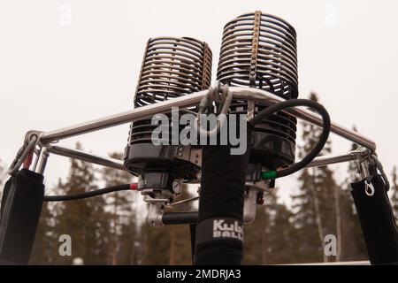 Ein Flug im Heißluftballon in Finnland. Fotoshooting, das gemacht wurde, als der Ballon zum Auftanken am Boden lag und während des Abhebens und Fluges. Kalter Wintertag Stockfoto