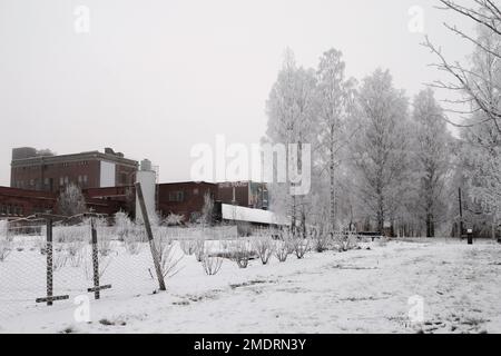 Fotoshooting in einer alten Fabrik, Graffiti-Kunstmauern, alten Industriebauten und eiskaltem Winterwetter. Schnee auf dem Boden Stockfoto