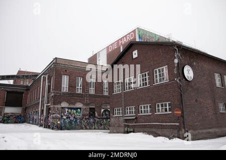 Fotoshooting in einer alten Fabrik, Graffiti-Kunstmauern, alten Industriebauten und eiskaltem Winterwetter. Schnee auf dem Boden Stockfoto