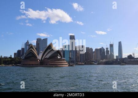 Der blaue Himmel über dem Opernhaus von Sydney mit Gebäuden am Circular Quay an einem sonnigen Tag Stockfoto