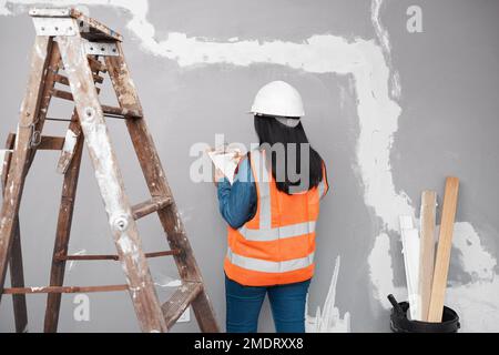 Ein Bauleiter überprüft das Renovierungsprojekt mit einer Checkliste auf der Zwischenablage Stockfoto