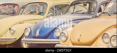 Eine Reihe klassischer, farbenfroher Autos der 70er Jahre Stockfoto
