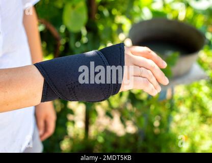 Universalfixateur des Handgelenkes an der Hand des Patienten. Bandage bei Fraktur und Verstauchung des Radiokarpalgelenkes, Schmerzen im Arm. Stockfoto