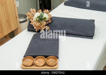 Holzgegenstände und Handtücher auf einem Massagetisch Stockfoto