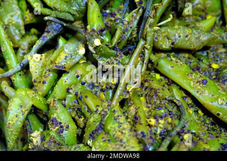 Hausgemachte rote oder grüne Chilispüree, indische würzige Gurken, indische Gewürze mit rohen roten und grünen Chilischoten, selektiver Fokus. Stockfoto