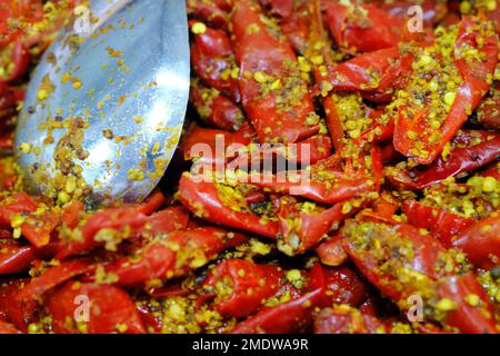 Hausgemachte rote oder grüne Chilispüree, indische würzige Gurken, indische Gewürze mit rohen roten und grünen Chilischoten, selektiver Fokus. Stockfoto