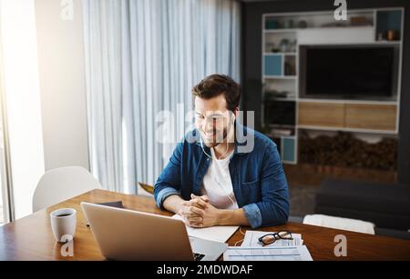 Seien Sie immer verfügbar, um mit Ihren Kunden zu sprechen. Ein gutaussehender junger Geschäftsmann, der sich hinsetzt und mit seinem Laptop Videoanrufe entgegennimmt, während er von arbeitet Stockfoto