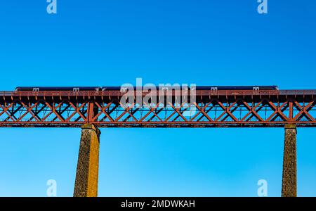 ScotRail Lokalzug überquert die viktorianische Kragarm Forth Rail Bridge an einem sonnigen Tag mit klarem blauen Himmel, Firth of Forth, Schottland, Großbritannien Stockfoto