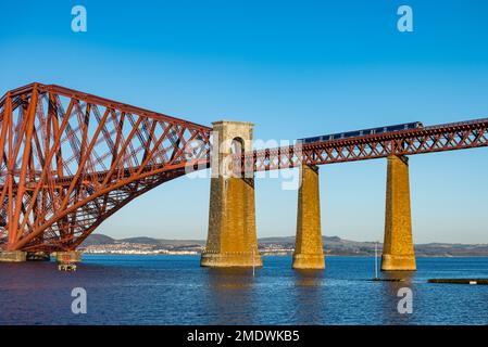 ScotRail Lokalzug überquert die viktorianische Kragarm Forth Rail Bridge an einem sonnigen Tag mit klarem blauen Himmel, Firth of Forth, Schottland, Großbritannien Stockfoto