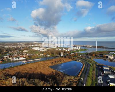 Luftaufnahme einer kleinen Stadt vor dem Meer unter blauem Himmel und Wolken Stockfoto