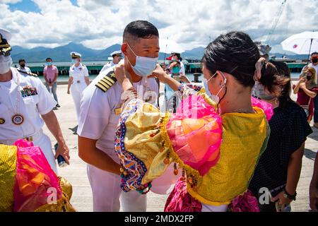 PUERTO PRINCESA, Philippinen (27. Juli 2022) – Kapitän Hank Kim, Befehlshaber der Mission Pacific Partnership 2022 (PP22), erhält eine traditionelle Kette von einem philippinischen Kulturtänzer bei der Ankunft in Puerto Princesa während des Anstoßes der Mission PP22 auf den Philippinen. Die Pazifikpartnerschaft ist die größte multinationale Mission zur Vorbereitung auf humanitäre Hilfe und Katastrophenhilfe, die jährlich im Indo-Pazifik durchgeführt wird. Sie ist seit 17. Jahren Teil der Partnerschaft. Stockfoto