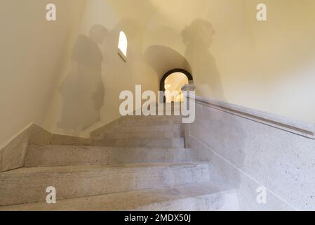 Frau in Langzeitbelichtung zu Fuß die Treppe mit Fenstern. Stockfoto