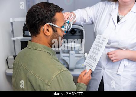 Ein dunkelhaariger Mann hat einen Termin in der Optikerpraxis Stockfoto