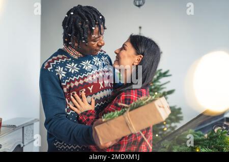 Ein multirassisches junges Paar feiert Weihnachten. Hochwertiges Foto Stockfoto