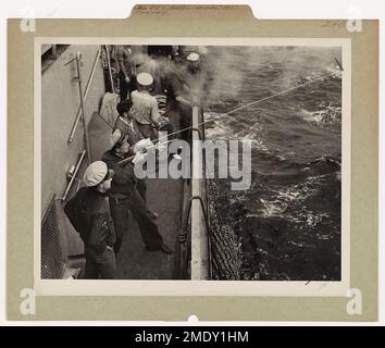 Küstenwache auf einer Zerstörereskorte unterstützen ein Handelsschiff im Mittelmeer, indem sie einen Arzt oder Patienten über eine Reisetoje transportieren. Die Küstenwache Gustav Peterson, George S. Drew und Dominic Garofalo sind an der Operation beteiligt. Stockfoto