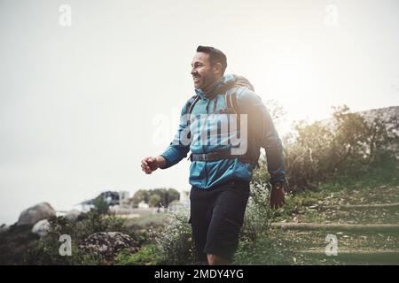 Ich glaube, ich bin auf dem richtigen Weg. Ein Mann mittleren Alters, der in den Bergen wandert. Stockfoto