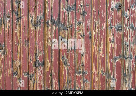Ein Teil der Wand mit verwitterten bemalten Brettern an der Außenseite eines Gebäudes in einer historischen Stadt von Colorado. Stockfoto