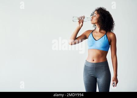 Wenn Sie Ihre Gesundheit verbessern, verbessern Sie Ihr Leben. Studiofoto einer sportlichen jungen Frau vor grauem Hintergrund. Stockfoto