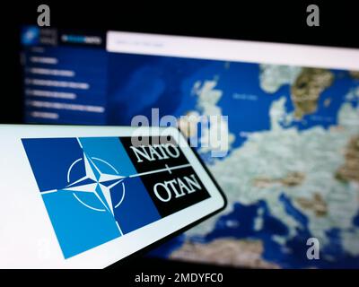 Smartphone mit Logo der NATO (Nordatlantikvertrags-Organisation) auf dem Bildschirm vor der Website. Fokus auf der linken Seite des Telefondisplays. Stockfoto