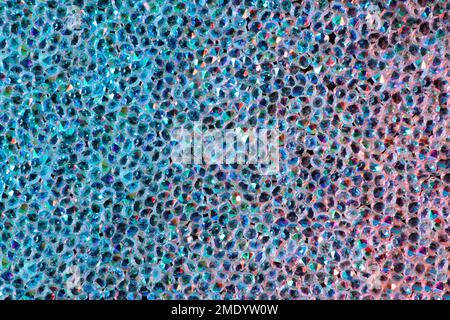 Abstrakter Strasssteinhintergrund. Textur von Strasssteinen, die mit mehrfarbigem Licht beleuchtet werden. Rosa und blaue glänzende Diamanten. Schließen. Leuchtfackeln auf Glas. Stockfoto