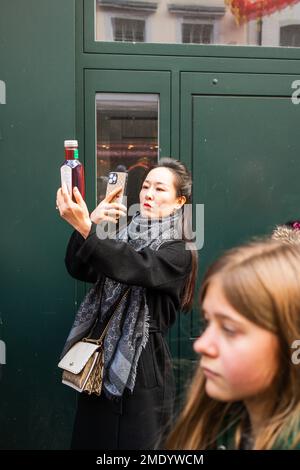 Asiatische Frau, die in China Town in London, England, Großbritannien telefoniert Stockfoto