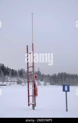 Verschneite Winterfotos in Tampere, Finnland. Die Boote liegen an der Küste und sind mit Schnee und Eis bedeckt. Der Winter ist gekommen und sieht eiskalt aus. Stockfoto