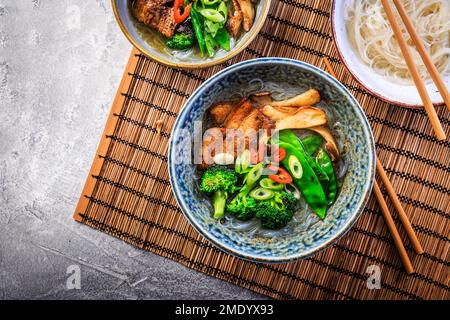 Ramen-Suppe mit Pilzen, Gemüse, Glasnudeln und Schweinefleisch Stockfoto