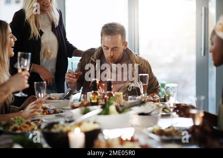 Er hat bereits alles, was er sich wünschen konnte. Ein junger Mann feiert seinen Geburtstag mit seinen Freunden. Stockfoto