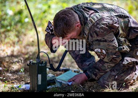 Sgt. Tyler Holloway von der Artilleriebrigade 115. in der Nationalgarde der Wyoming Army betreibt beim National Best Warrior Competition, der am 26. Juli 2022 auf der Mailand Volunteer Training Site, Tennessee, stattfindet, ein Single Channel Ground and and Airborne Radio System in einer Spur. Der Tag bestand aus einer Reihe von Veranstaltungen, zu denen die Unfallverhütung, ein Feuerruf und improvisierte Sprengstoffspuren gehörten. Der National Best Warrior Competition hat die besten Soldaten der Army National Guard. Stockfoto