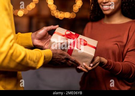Nicht wiedererkennbarer schwarzer Mann und Frau mit Geschenkbox Stockfoto