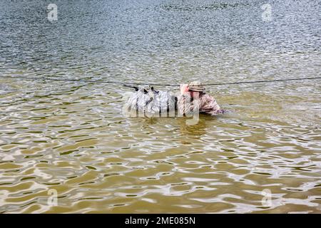 Sgt. Tyler Holloway von der Artilleriebrigade 115. in der Nationalgarde der Wyoming Army transportiert seine Ausrüstung auf einer Wasserüberquerung, die Teil eines geheimnisvollen Events beim National Best Warrior Competition war, der am 26. Juli 2022 auf der Mailänder Trainingsstätte für Freiwillige stattfand. Der Tag bestand aus einer Reihe von Veranstaltungen, zu denen die Unfallverhütung, ein Feuerruf und improvisierte Sprengstoffspuren gehörten. Der National Best Warrior Competition hat die besten Soldaten der Army National Guard. Stockfoto