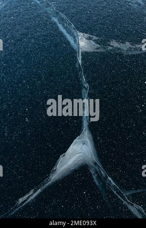 Natürliches blaues Eis am See. Wunderschöne Winterlandschaft. Eisrisse, gefrorene Seenoberfläche. Sonnige Landschaften am Baikal-See, Sibirien Russland Stockfoto