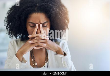 Diese Kopfschmerzen helfen mir auch nicht weiter. Eine junge Geschäftsfrau, die in ihrem Büro gestresst aussieht. Stockfoto