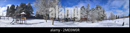 Panoramafoto des mit Schnee bedeckten Kinderspielbereichs im öffentlichen Park. Webbanner Stockfoto