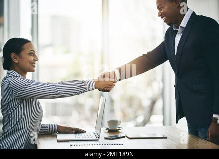 Erfolg beginnt mit der Zusammenarbeit mit den richtigen Personen. Zwei Geschäftsleute, die sich in einem Büro die Hand schütteln. Stockfoto